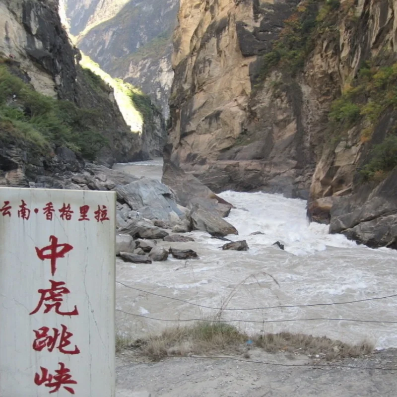 中虎跳峽壯麗峽谷景觀，金沙江激流穿越高聳岩壁之間，峽谷地形險峻壯觀，兩側山壁陡峭岩石林立，展現雲南香格里拉著名自然奇景與中虎跳峽雄偉的峽谷地貌