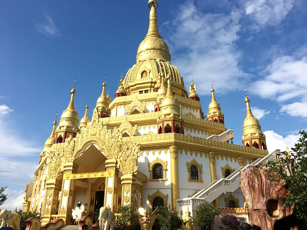 Menghuan Great Golden Pagoda 孟桓大金塔金碧輝煌的佛塔建築,塔身層層疊起並以金色裝飾點綴,在藍天白雲映襯下格外壯麗,融合東南亞佛教建築風格,展現孟桓大金塔莊嚴宏偉的宗教與文化景觀