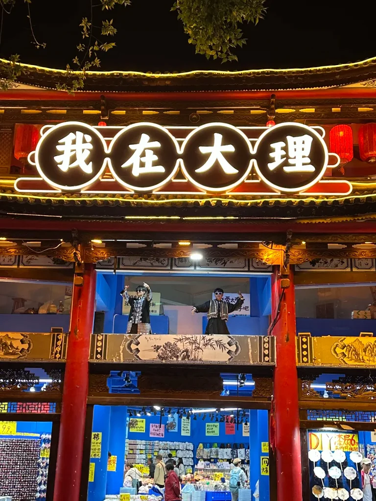 大理古城夜晚街景，傳統建築與燈光招牌交織，呈現熱鬧氛圍。