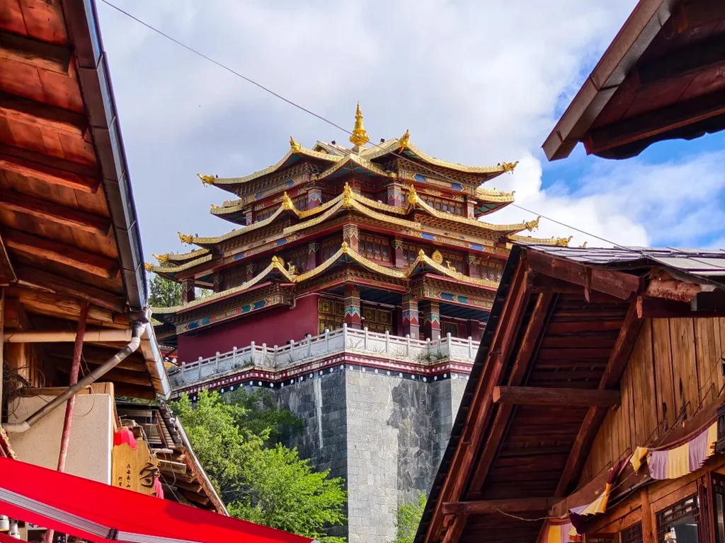 香格里拉獨克宗古城大佛寺,金頂層疊藏式古殿雄偉莊嚴,聳立高原山巔,夾在原木藏式民居古巷之間,滿載千年藏傳佛教聖地風韻。