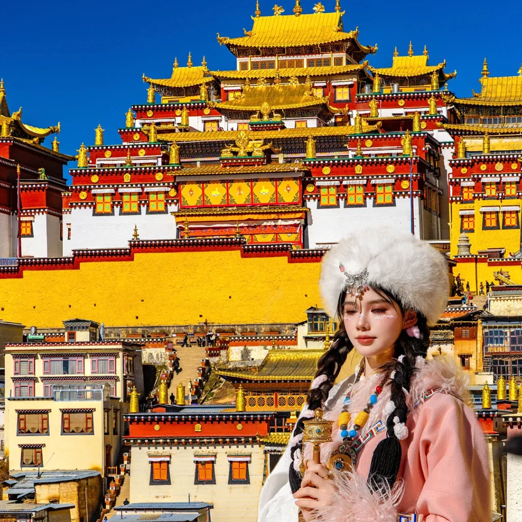 在 松贊林寺 前,遊客身著藏族傳統服飾拍照留念,金頂寺廟群莊嚴宏偉,色彩鮮豔,人物與藏式建築相互映襯,充滿民族風情。