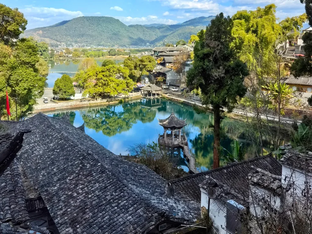Tengchong Heshun Ancient Town 騰衝和順古鎮的核心湖景,亭台立於澄澈湖面,灰瓦民居環繞,遠山與藍天倒映水中,是古鎮最具代表性的山水畫卷。