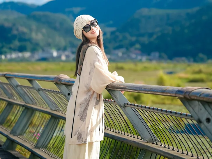 Outfit 3 騰衝北海濕地公園的觀景橋打卡點,靠在欄杆上,背後是遼闊濕地與遠山,拍出超有度假感的旅遊大片。
