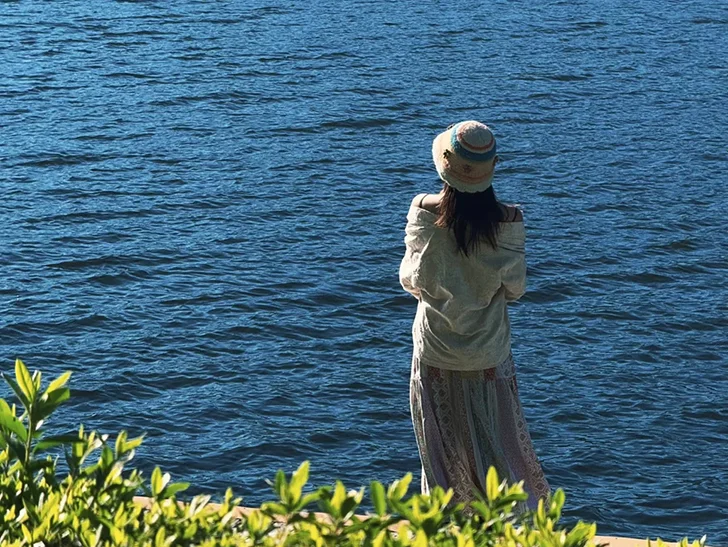 Outfit 5 騰衝北海濕地公園的湖岸風光,深藍色的湖面波光粼粼,搭配前景綠葉,拍出超治愈的度假感背影照。