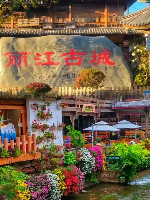 Lijiang Old Town 2 麗江古城著名的大水車景觀,巨大的木製水車在清澈河道旁緩緩轉動,周圍是傳統納西族建築與古城街景,遊客漫步其間,展現麗江古城融合歷史文化與自然水景的特色風光。